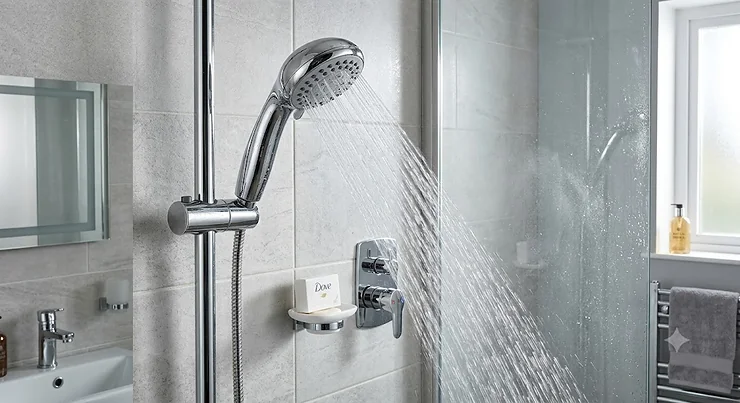 A modern chrome handheld shower head for low water pressure installed in a contemporary British bathroom.