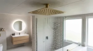 Luxury en-suite bathroom showcasing a brushed brass ceiling mounted rain shower head with elegant overhead water delivery.