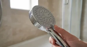 Close up of a multi mode handheld shower head showing the dial to change spray patterns.