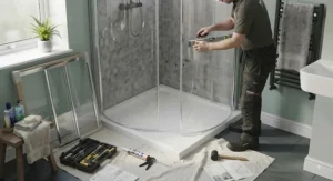 A quadrant shower enclosure being fitted in a compact UK en-suite bathroom