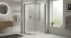 A sleek, frameless quadrant shower enclosure installation in a contemporary British bathroom setting.