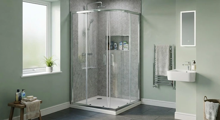 A sleek, modern quadrant shower enclosure installed in a small British bathroom