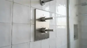 A sleek thermostatic shower valve fitted on tiled walls in a contemporary British bathroom