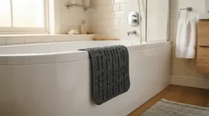 Mould-resistant rubber non-slip shower mat drying over the edge of a bath